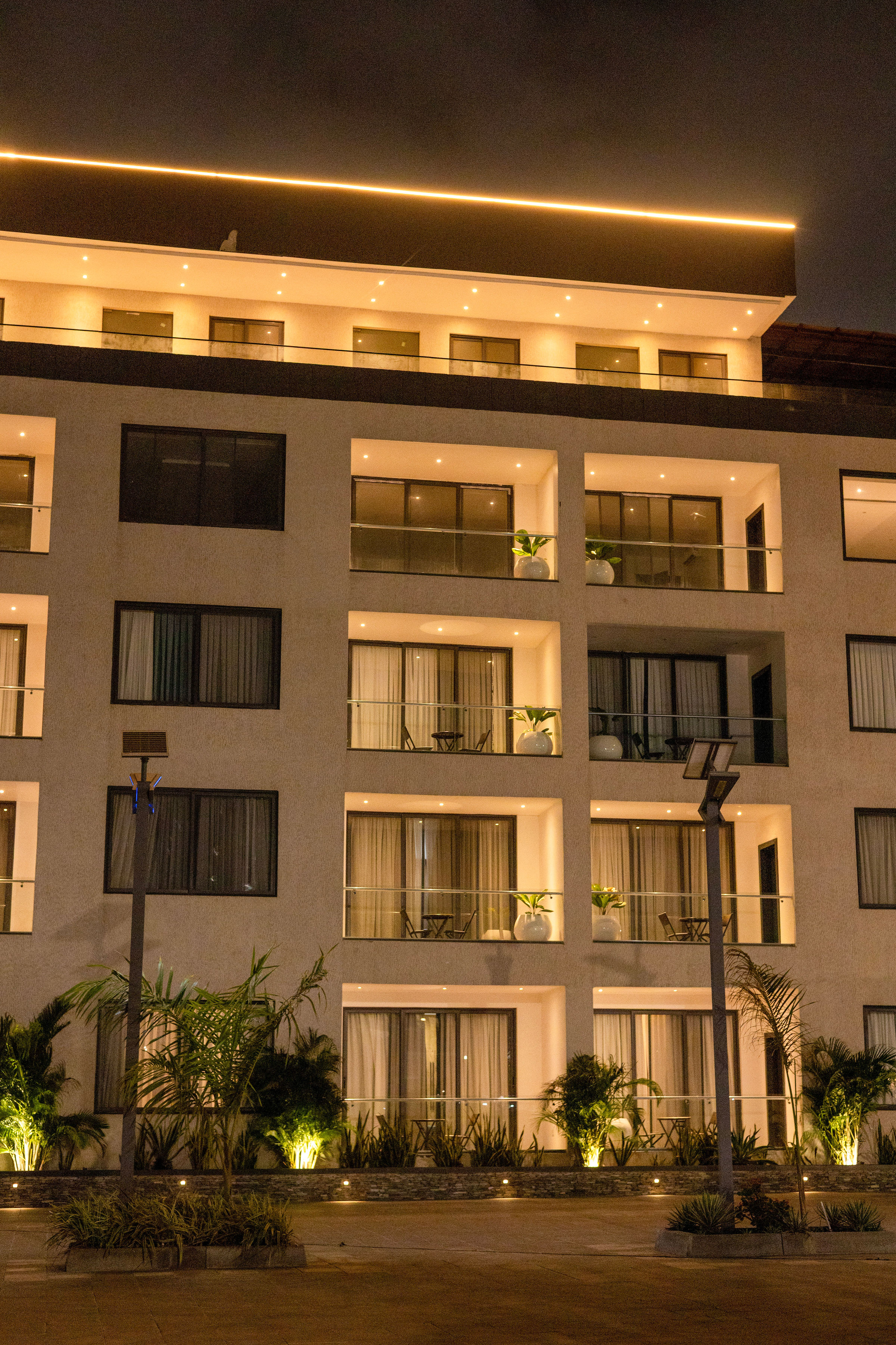 The patterned façade and balconies lit after dark